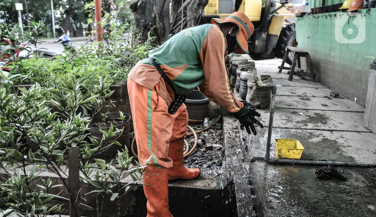 Petugas Sudin LH membersihkan diri usai bertugas di Dipo Sampah Kecamatan Pademangan, Ancol, Jakarta, Rabu (24/2/2021). Ikhasnudin mengatakan menangani sampah masker dengan mengguntingnya serta dibungkus sebelum dibuang guna mengurangi risiko penularan virus Covid-19.  (merdeka.com/Iqbal S. Nugroho)