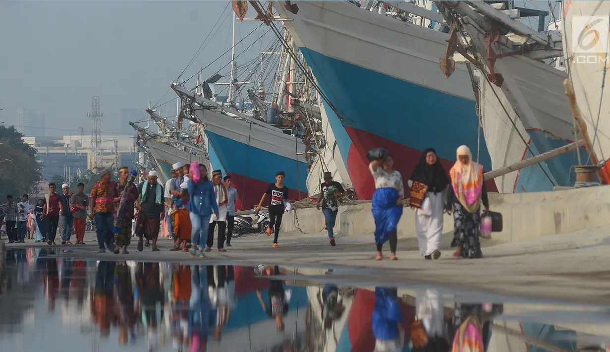 Warga berjalan bersiap menunaikan salat Idul Fitri 1439 H di Pelabuhan Sunda Kelapa, Jakarta, Jumat (15/6). Seluruh umat islam merayakan hari Idul Fitri 1349 H yang jatuh pada Jumat, 15 Juni 2018.            (Merdeka.com/Imam Buhori)