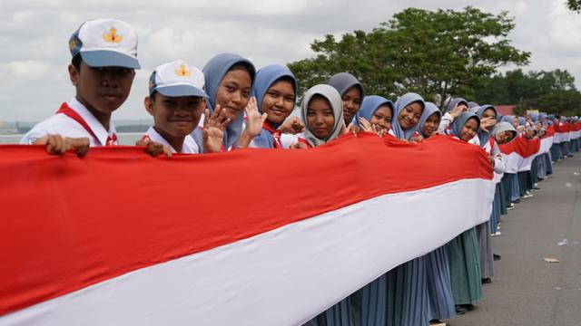 Aksi bentang kain merah putih 17 kilometer di Kota Kendari, memeriahkan HUT ke-78 RI, Selasa (15/8/2023).(liputan6.com/foto deni lahundape)
