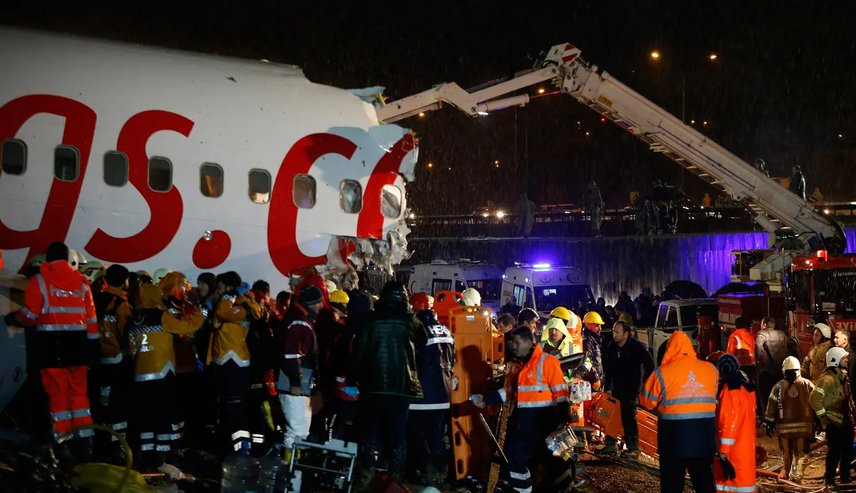 Tim penyelamat dan petugas pemadam kebakaran bekerja setelah sebuah pesawat tergelincir di landasan pacu Bandara Sabiha Gokcen, Istanbul, Turki, Rabu (5/2/2020). Pegasus Airlines telah mengonfirmasi tentang kecelakaan ini, tapi belum memberikan rincian lebih lanjut. (AP Photo/Emrah Gurel)