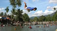 Seorang pemuda melopat dari ketinggian saat melakukan tradisi mensucikan diri (Balimau) di pemandian Lubuk Minturun, Padang, Sumbar. (Antara)