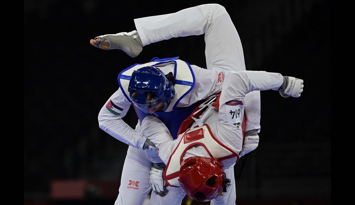 Saleh Elsharabaty dari Yordania (Biru) dan Achraf Mahboubi dari Maroko (Merah) berlomba dalam perempat final taekwondo putra -80kg Olimpiade Tokyo 2020 di Makuhari Messe Hall di Tokyo, Senin (26/7/2021). (Foto: AFP/Javier Soriano)