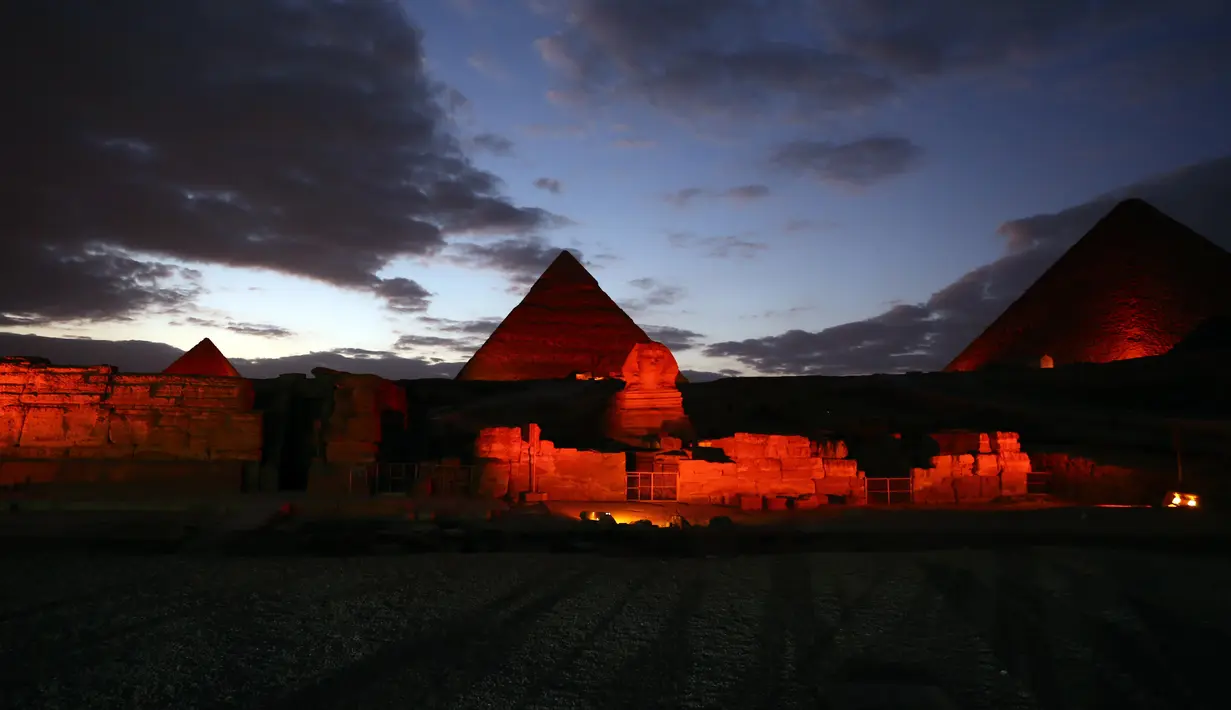 Patung Sphinx dan sejumlah piramida berwarna merah saat pertunjukan cahaya dan suara di Giza, Mesir, Kamis (23/1/2020). Pertunjukan tersebut digelar sebagai bagian dari perayaan Tahun Baru Imlek. (Xinhua/Ahmed Gomaa)