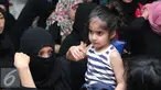 Seorang anak Tenaga Kerja Indonesia saat menunggu di Bandara Soekarno Hatta, Tangerang, Rabu (11/11/2015). Para TKI perempuan tersebut hampir sebagian pulang membawa anak-anak mereka yang wajahnya lucu dan menggemaskan. (Liputan6.com/Angga Yuniar)