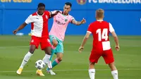 Gelandang Barcelona, Sergio Busquets, berebut bola dengan pemain Girona, Ibrahima Kebe, pada laga uji coba di Stadion Johan Cruyff, Barcelona, Kamis (17/9/2020). Barcelona menang 3-1 atas Girona. (AP/Joan Monfort)