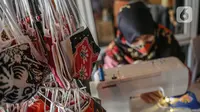 Perajin menyelesaikan pembuatan masker batik di Butik Elemwe, Jakarta, Jumat (2/10/2020). Badan Standardisasi Nasional (BSN) mengeluarkan spesifikasi masker kain ber-SNI yang terbagi menjadi tiga tipe berdasarkan penggunaannya. (Liputan6.com/Faizal Fanani)