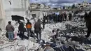 Orang-orang mencari melalui puing-puing bangunan yang runtuh tempat bayi perempuan yang baru lahir ditemukan di kota Jinderis, provinsi Aleppo, Suriah, Selasa (7/2/2023). Dokter anak Hani Maarouf mengatakan kepada AFP bahwa kondisi bayi tersebut stabil tetapi terdapat memar, luka robek, dan hipotermia. (AP Photo/Ghaith Alsayed)