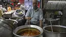 Dalam gambar pada 3 April 2022, penjaga toko berpose dengan hidangan di sebuah restoran di pasar pada hari pertama Ramadhan di kawasan tua Delhi, India. Masjid dan jalan-jalan pasar penuh dengan keramaian malam, tergoda oleh aroma manisan manis untuk berbuka puasa. (Money SHARMA/AFP)