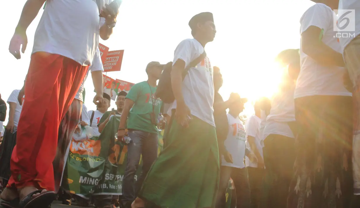 Para santri mengikuti jalan sehat sarungan di kawasan Monas, Jakarta, Minggu (30/9). Jalan sehat tersebut dilakukan dalam rangka memperingati Hari Santri yang jatuh pada 22Oktober mendatang. (Liputan6.com/Angga Yuniar)