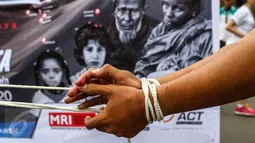 Demonstran dengan tangan diikat melakukan aksi keprihatinan saat CFD di Bundaran HI, Jakarta (14/08). (Liputan6.com/Fery Pradolo).