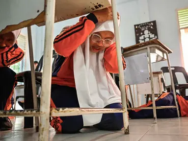 Sejumlah siswa Sekolah Menengah Atas (SMA) mengikuti simulasi gempa bumi dan tsunami untuk memperingati Hari Kesadaran Tsunami Sedunia di Lhoknga, Provinsi Aceh, pada Rabu 5 November 2025. Bertepatan dengan peringatan Hari Kesadaran Tsunami Sedunia setiap tanggal 5 November, siswa salah satu SMA di Lhoknga, Provinsi Aceh, menggelar simulasi mitigasi bencana alam, seperti gempa bumi dan tsunami. (CHAIDEER MAHYUDDIN/AFP)