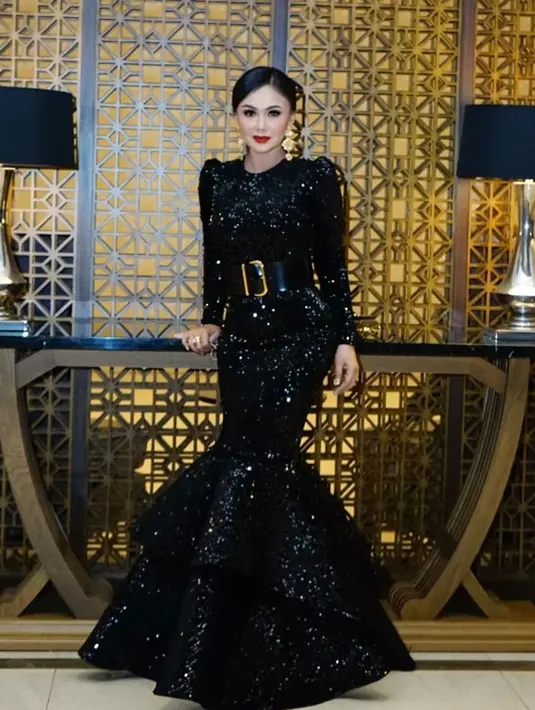 Tampil dengan dress panjuang berwarna hitam bermodel duyung, Yuni Shara pun melengkapi penampilannya dengan ikat pinggang cukup besar. Tak hanya itu saja, riasan wajahnya yang sederhana pun hanya menonjolkan pada lipstik merah. (Liputan6.com/IG/@yunishara36)