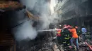 Petugas pemadam kebakaran berusaha memadamkan api setalah api melahap gedung apartemen yang juga digunakan sebagai gudang bahan kimia di Dhaka (21/2). Setidaknya 69 orang tewas dalam kebakaran besar tersebut. (AFP Photo/Munir Uz Zaman)