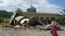 Seorang bocah berjalan melewati sebuah masjid yang rusak usai gempa di Pidie Jaya, Aceh, Rabu (7/11). Selain meruntuhkan bangunan, gempa bumi berkuatan 6,4 SR ini telah menelan banyak korban jiwa. (AFP PHOTO / Chaideer Mahyuddin)