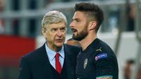 Olivier Giroud merayakan selebrasi dengan pelatihnya Arsene Wenger setelah mencetak hattrick melawan Olympiakos di Stadion Georgios Karaiskakis, Piraeus, Yunani  (9/12). Arsenal menang atas Olympiakos dengan skor 3-0. (Reuters/Andrew Couldridge)