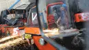 Pekerja menghancurkan bajaj dengan memotong beberapa bagian menggunakan las, Jakarta, Rabu (4/3/2015). (Liputan6.com/Herman Zakharia)