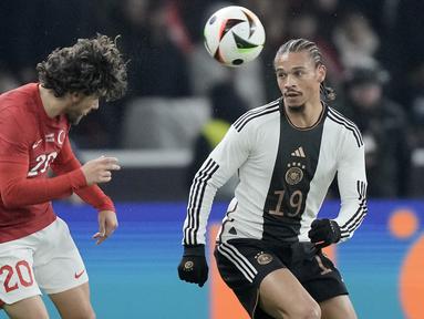 Gelandang Turki Ferdi Kadioglu berebut bola dengan penyerang Jerman Leroy Sane dalam laga uji coba di Olympiastadion, Berlin, Minggu (19/11/2023) dini hari WIB. (AP Photo/Markus Schreiber)