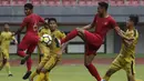 Bek Timnas Indonesia U-22, Andy Setyo, berusaha melepas tendangan saat melawan Bhayangkara FC pada laga uji coba di Stadion Patriot, Bekasi, Rabu (6/2). Keduanya bermain imbang 2-2. (Bola.com/Yoppy Renato)