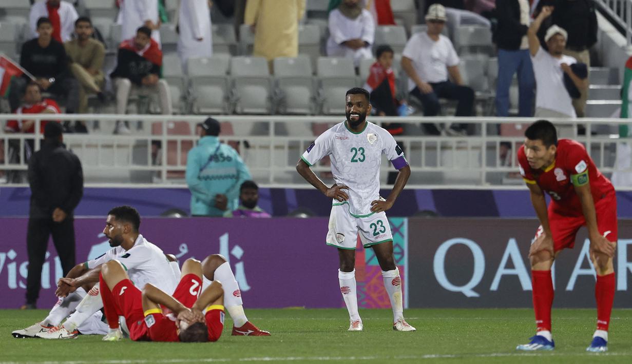 Para pemain Timnas Oman dan Kirgistan tertunduk lesu setelah bermain imbang 1-1 pada laga ketiga Grup F Piala Asia 2023 di Abdullah bin Khalifa Stadium, Doha, Qatar, Kamis (25/1/2024) yang membuat Oman dan Kirgistan gagal lolos ke babak 16 besar. (AFP/Karim Jaafar)