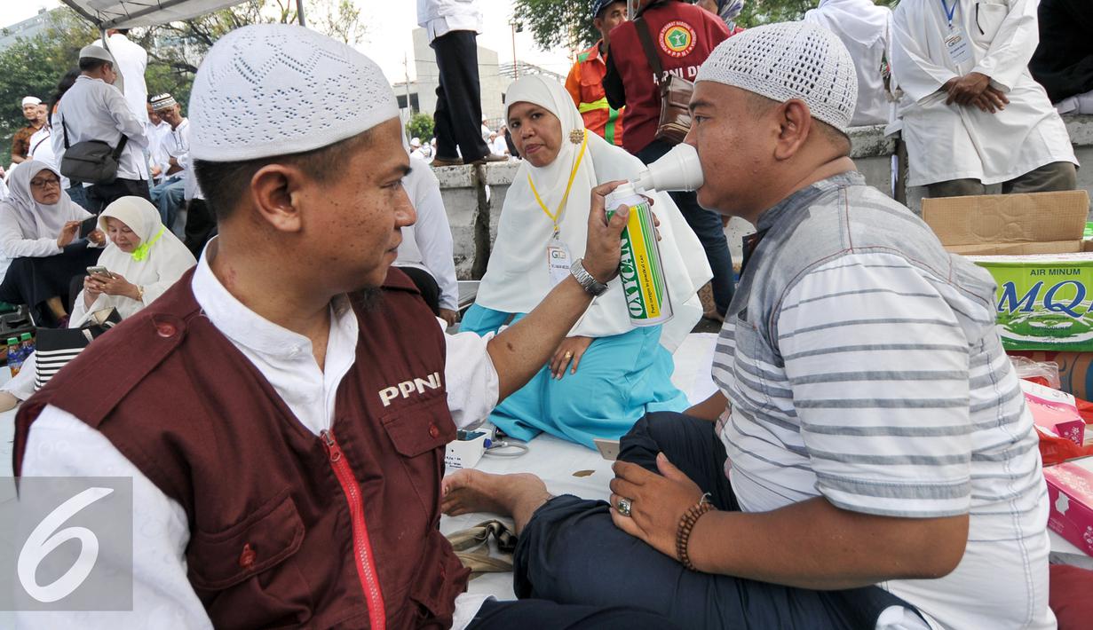 Relawan memberikan oksigen buatan kepada demonstran yang kelelahan saat mengikuti gerakan massa 4 November, Jakarta, Jumat (4/11). Relawan kesehatan ini siaga bantu para demonstran yang kelelahan atau sakit saat aksi demo. (Liputan6.com/Yoppy Renato)