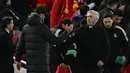 Pelatih Liverpool Jurgen Klopp (kiri) dan pelatih Real Madrid Carlo Ancelotti berjabat tangan usai pertandingan melawan Real Madrid pada pertandingan leg pertamababak 16 besar Liga Champions di stadion Anfield di Liverpool, Inggris, Rabu (22/2/2023). Liverpool kalah telak dari Madrid dengan skor 2-5. (AFP/Paul Ellis)