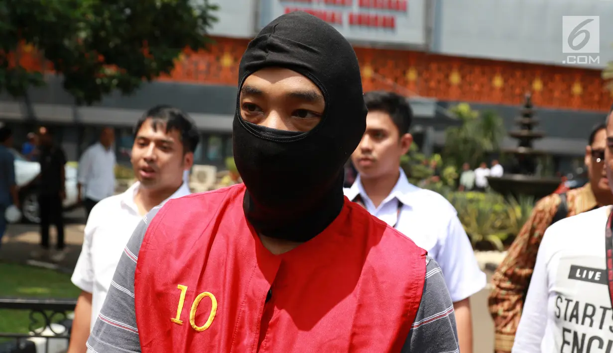 Tersangka kasus skimming ATM Ramyadjie Priambodo saat akan dilimpahkan ke kejaksaan di Polda Metro Jaya, Jakarta, Kamis (25/4). Pelimpahan tahap dua dilakukan usai kejaksaan menetapkan berkas perkara Ramyadjie lengkap (P-21) secara materiil dan formil pada 18 April 2019. (Liputan6.com/Immanuel Anton