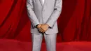 Kelvin Harrison Jr. mengenakan setelan wol abu-abu dengan kemeja poplin abu-abu muda dan dasi satin abu-abu muda. Sepatu boots kulit hitam yang disikat. [Prada]