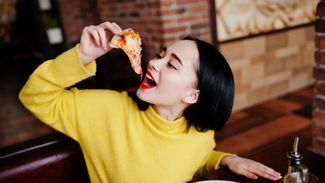 perempuan baju kuning makan dengan bahagia
