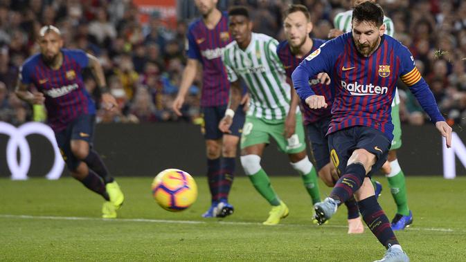 Lionel Messi mencetak gol untuk Barcelona melalui tendangan penalti pada laga melawan Real Betis. (AFP/Josep Lago)