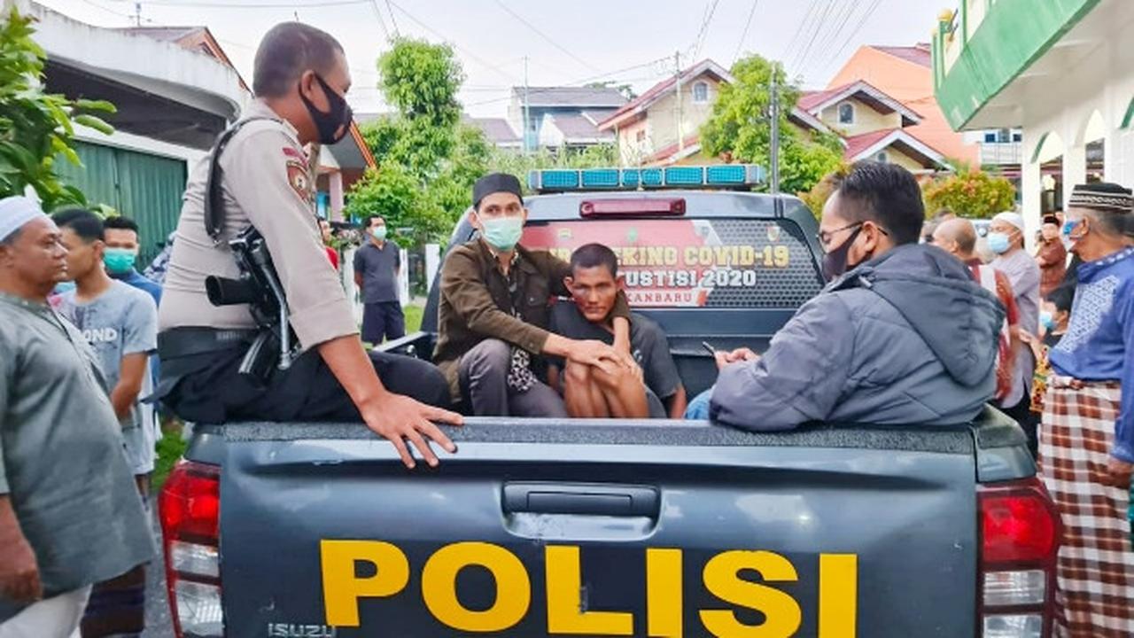 Personel Polsek Tampan membawa pelaku penyerangan imam di sebuah masjid di Pekanbaru.