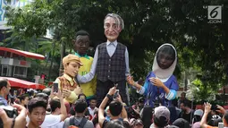 Empat boneka asal Prancis dari Kelompok teater Les Grandes Personnes hibur warga saat CFD di Jakarta, Minggu (9/7). Acara tersebut dilakukan untuk penggalangan dana guna membantu pengembangan pendidikan di Indonesia. (Liputan6.com/Immanuel Antonius)
