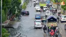 Genangan air yang tinggi membuat permukaan got tidak tampak. Ini yang membuat mobil sering terjeblos. Tingginya air juga kerap membuat kendaraan menjadi mogok (Liputan6.com/Panji Diksana)