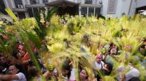 Para umat Kristiani mengacungkan daun palem mereka selama upacara pemberkatan di luar Katedral Antipolo, kota Antipolo, provinsi Rizal, Filipina, saat memperingati Minggu Palma, 29 Maret 2026. (AP Photo/Aaron Favila)
