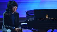 Senyum pianis muda Indonesia, Joey Alexander saat tampil di ajang Grammy Awards 2016 di Los Angeles, Senin (15/2). Sorotan industri musik internasional semakin besar terhadap Joey setelah tampil dalam malam puncak penghargaan Grammy (AFP PHOTO/Robyn BECK)
