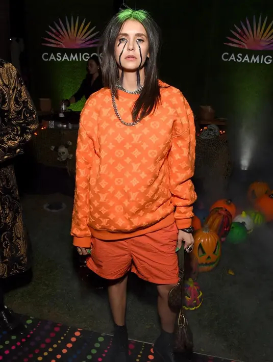 Selanjutnya ada Nina Dobrev yang merayakan Halloween dengan mengenakan pakaian serba bermerk Louis Vuitton dan rambut hijau serta tangis air mata berwarna hitam sebagai Billie Eilish. (Instagram/nina)