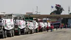 Orang-orang berjalan melewati truk-truk yang dimuat dengan bantuan untuk Gaza, menunggu di sisi Mesir dari pos perbatasan Rafah pada 18 Agustus 2025. (Khaled DESOUKI/AFP)