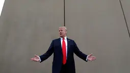 Presiden AS, Donald Trump berbincang saat melakukan perjalanan untuk melihat prototipe tembok perbatasan AS dan Meksiko di San Diego, Selasa (13/3). Tembok ini adalah perwujudan dari janji Trump pada kampanye presiden 2016 lalu. (AP/Evan Vucci)