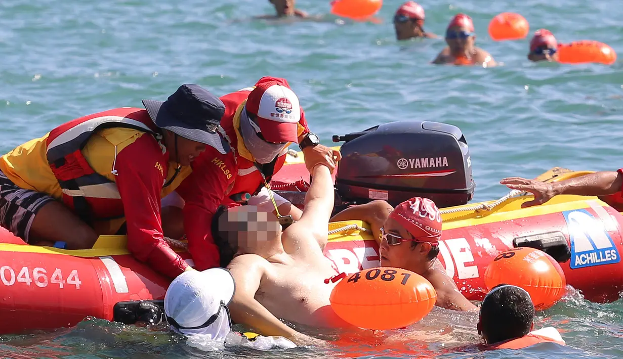 Seorang perenang diangkat dari air dalam keadaan tidak sadar oleh petugas penyelamat ketika mengikuti lomba renang lintas pelabuhan berjarak 1.500 meter di Hong Kong, Minggu (16/10). Perenang itu tewas saat dilarikan ke rumah sakit. (REUTERS/APPLE DAILY)