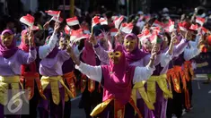 Sejumlah peserta membawa bendera merah putih saat mengikuti pawai pembangunan melintasi Jalan Malioboro, Yogyakarta, Minggu, (20/8. Pawai pembagunan diselenggarakan di tiap tiap daerah setiap tahun setelah peringatan HUT RI. (Liputan6.com/Boy Harjanto)