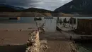 Foto ini menunjukkan sisa-sisa rumah yang muncul kembali ketika permukaan danau buatan Mornos menurun akibat kekeringan, di desa Kallio, sekitar 240 km barat laut Athena, Yunani pada 3 November 2025. Untuk diketahui, danau buatan Mornos sengaja dibuat pada akhir tahun 1970-an dan awal 1980-an untuk menyediakan pasokan air bagi hampir separuh populasi Yunani, termasuk ibu kota Athena, yang membuat desa asli Kallio sengaja ditenggelamkan. (Angelos TZORTZINIS/AFP)