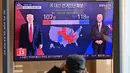 Orang-orang menonton program berita televisi tentang pemilihan presiden (pilpres) AS yang menampilkan gambar Presiden Donald Trump (kiri) dan calon presiden dari Partai Demokrat Joe Biden (kanan), di sebuah stasiun kereta api di Seoul, Korea Selatan pada Rabu (4/11/2020). (Photo by Jung Yeon-je/AFP)