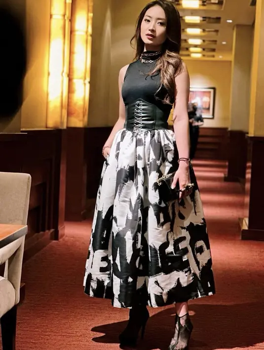 <p>Natasha Wilona tampil monokrom mengenakan sleeveless turtleneck hitam untuk atasan. Dipadukan skirt hitam putih, dan obi bertali. Ia menenteng handbag dan mengenakan heels transparan hitam. (@natashawilona12)</p>