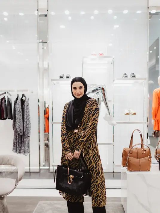 <p>Zaskia Sungkar memesona dalam balutan dress bermotif rantai emas dari koleksi spring/summer 2023 Michael Kors. Ia padukan dengan celana panjang hitam, hijab hitam polos, dan tas yang juga berasal dari Michael Kors yang serasi. Inspirasi gaya versatile untuk tampilan yang lebih santun. Foto: Document/Michael Kors.</p>