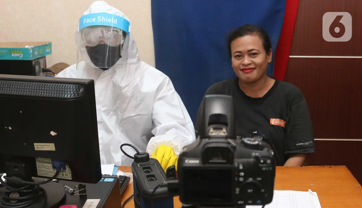 Petugas menggunakan Alat Pelindung Diri (APD) saat melayani warga yang mengajukan pembuatan KTP Elektronik di Pondok Aren, Tangerang Selatan, Senin (15/6/2020). Penggunaan APD ini bertujuan meminimalisir kontak fisik sebagai upaya pencegahan penularan Corona COVID-19. (Liputan6.com/Angga Yuniar)