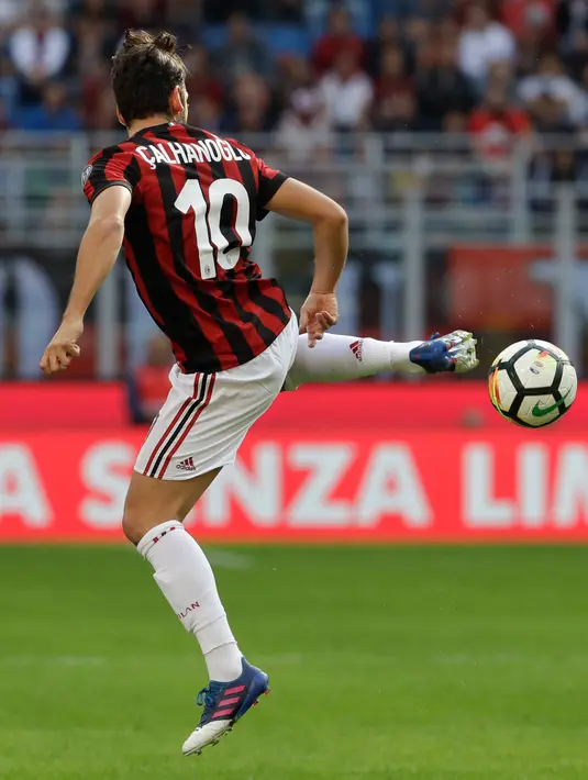 Gelandang AC Milan, Hakan Calhanoglu berusaha mengontrol bola dari kawalan pemain Udinese, Kevin Lasagna saat bertanding pada lanjutan Liga Serie A Italia di stadion San Siro, Milan, (17/9). AC Milan menang atas Udinese 2-1. (AP Photo/Luca Bruno)