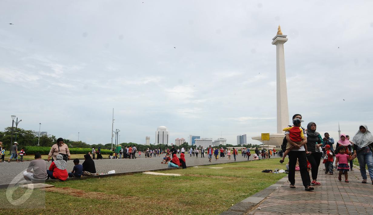 Warga berjalan-jalan di kawasan Monumen Nasional, Jakarta, Minggu (25/12). Libur perayaan Natal 2016 dimanfaatkan sejumlah warga untuk berwisata di kawasan Monumen Nasional. (Liputan6.com/Helmi Fithriansyah)