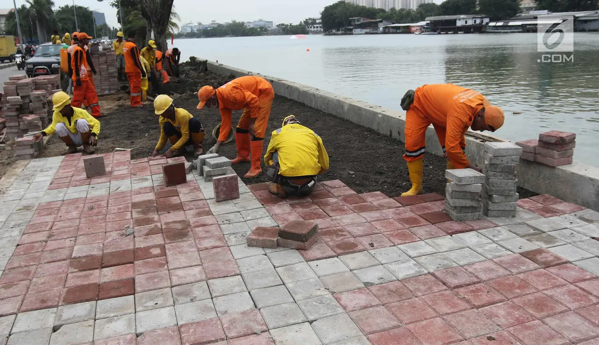 Petugas memasang konblok di pinggir Danau Sunter, Jakarta Utara, Senin (19/2). Progres penataan Danau Sunter telah mencapai 70 persen dan menargetkan penataan rampung sebelum pelaksanaan Festival Danau Sunter. (Liputan6.com/Arya Manggala)