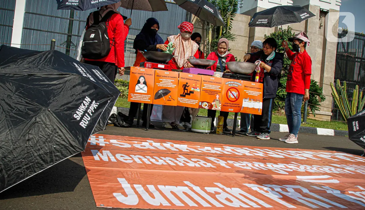 Para pendemo ini membawa poster dan juga membawa payung hitam bertuliskan "Sahkan RUU PRT". (Liputan6.com/Faizal Fanani)