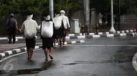Empat warga Baduy berjalan kaki melintasi kawasan Bundaran HI, Jakarta, Selasa (6/9). Warga Baduy berjalan ratusan kilometer dari kampung mereka tanpa alas kaki dan sama sekali tidak menggunakan kendaraan bermotor. (Liputan6.com/Faizal Fanani)