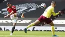 Pemain Manchester United Bruno Fernandes menendang bola di depan pemain Burnley Matthew Lowton pada pertandingan Liga Inggris di Stadion Old Trafford, Manchester, Inggris, Minggu (18/4/2021). Manchester United menang 3-1. (Martin Rickett/Pool via AP)